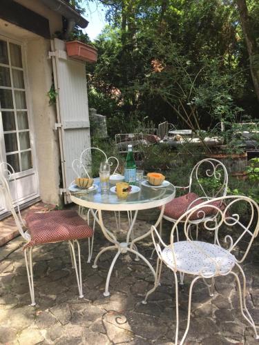 une table et des chaises assises sur une terrasse dans l'établissement Rustic Forest House, Barbizon, à Arbonne