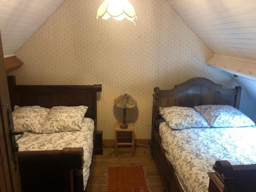 - une chambre avec 2 lits et une lampe dans l'établissement Rustic Forest House, Barbizon, à Arbonne