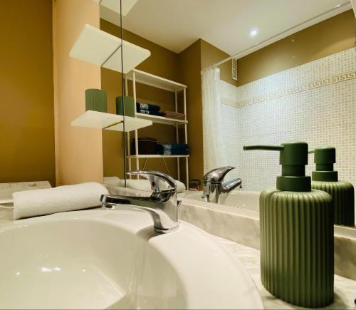 La salle de bains est pourvue d'un lavabo et d'un distributeur de savon vert. dans l'établissement Studio Cannes la Croisette, à Cannes