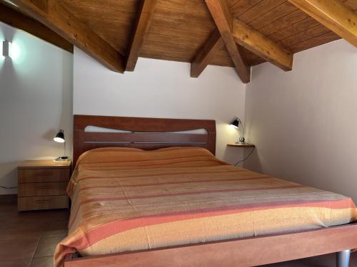 1 dormitorio con cama y techo de madera en Piccola Oasi - rifugio e relax, en Diano Marina