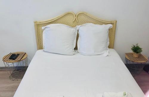 - un lit avec des draps et des oreillers blancs dans l'établissement 