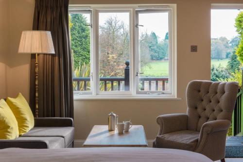 a room with a bed and two chairs and a window at Burley Manor in Burley