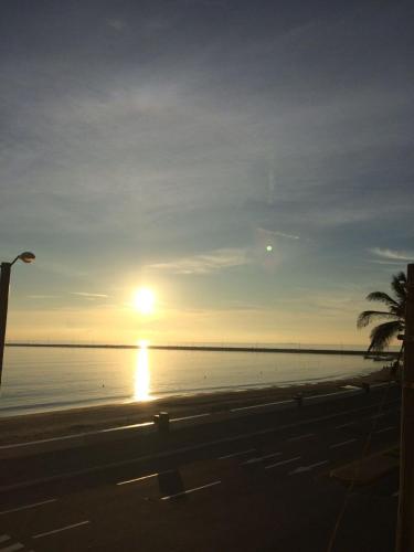 a sunset on the beach with a palm tree at Hotel Royalty in Veracruz