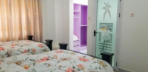 a bedroom with two beds in a room with purple at RS Royal Executive Luxurious 3BR Apartment F3-3 and 2BR Apartment F3-2 in Pantang