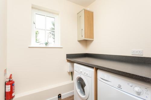 a laundry room with a washer and dryer at Watercress Lodges & Campsite in New Alresford