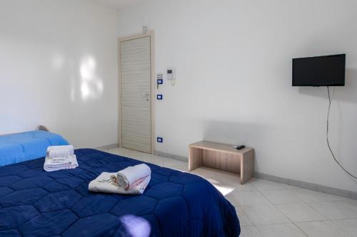 a bedroom with a blue bed and a television at Appartamenti DueC in Trapani