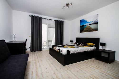 a bedroom with a bed and a couch at The Inn in Corralejo