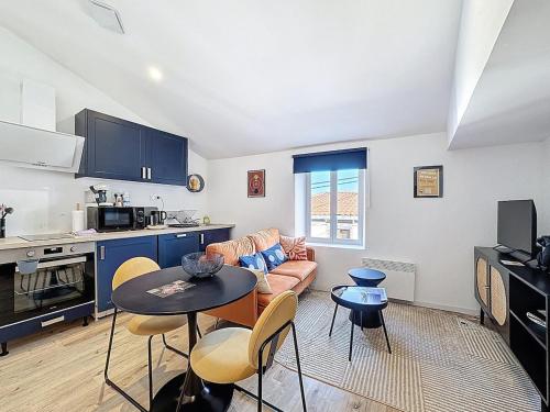 une cuisine et un salon avec un canapé et une table dans l'établissement Joli T1 cosy & fonctionnel 2Personnes Aulnat4, à Aulnat