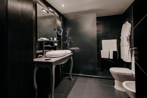 a black bathroom with a sink and a toilet at 138 Liberdade Hotel in Lisbon