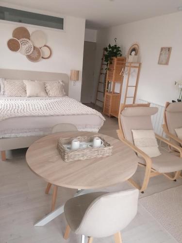 une chambre avec un lit, une table et des chaises dans l'établissement La parenthèse, à Béthisy-Saint-Pierre