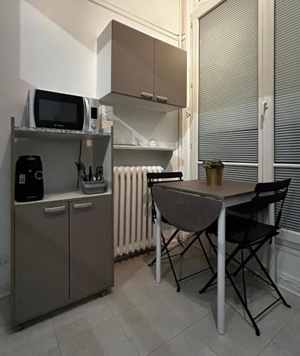 une petite cuisine avec une table et un micro-ondes dans l'établissement CHAMPS ELYSEES No 76, à Paris