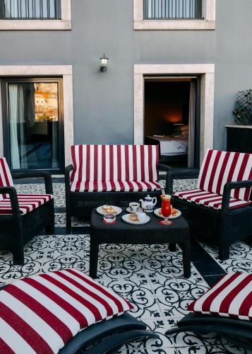 a patio with couches and a table and a fireplace at 138 Liberdade Hotel in Lisbon