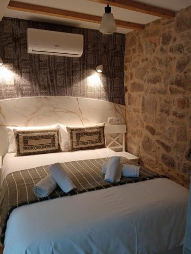 a bedroom with two beds and a stone wall at Casa Marisa Padron, Camino de Santiago in Padrón