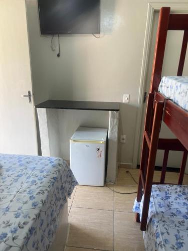 a room with two bunk beds and a television at Pousada Sol Nascente in Olímpia