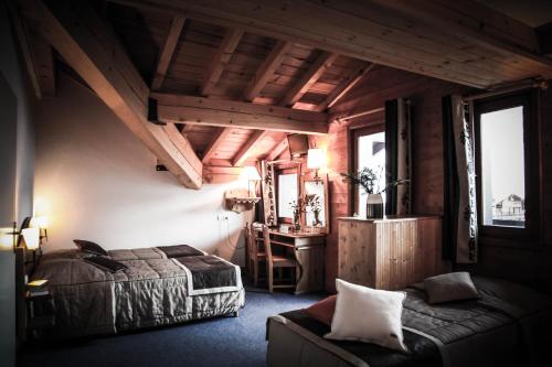 a bedroom with a bed and a chair in a room at Hôtel Le Refuge in Tignes