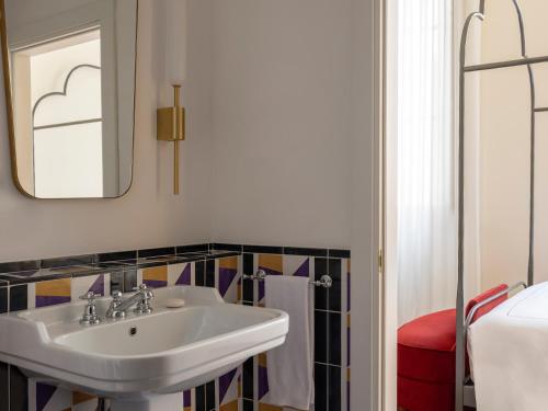 a bathroom with a sink and a mirror at Palazzo Talìa - Small Luxury Hotels of the World in Rome