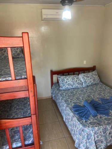 a bedroom with a bed and two bunk beds at Pousada Sol Nascente in Olímpia