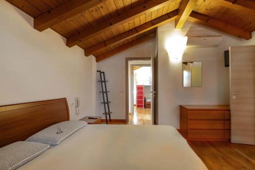 a bedroom with a bed and a wooden ceiling at Dimora all'Angolo - moderno e in centro in Affi