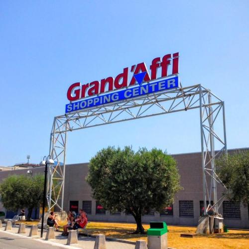 a sign for the grand entrance to a shopping center at Dimora all'Angolo - moderno e in centro in Affi