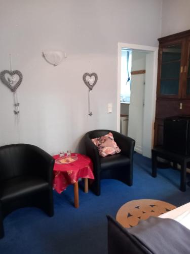 a living room with two black chairs and a table at Altstadt Oase Bernkastel-kues in Bernkastel-Kues