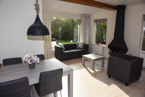 una sala de estar con una mesa y una chimenea en Bungalow Californiëweg 168 De Koog, Texel, en De Koog