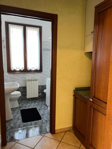 a bathroom with a sink and a toilet and a window at Green House in Somma Lombardo