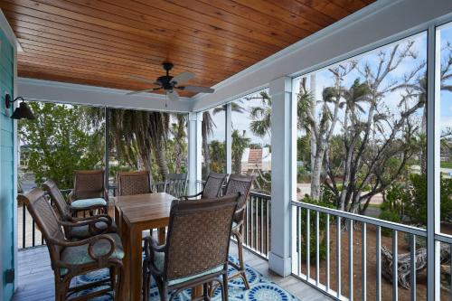 a screened porch with a table and chairs and a ceiling fan at Gorgeous Villa in Coveted Butterknife Community in Sanibel