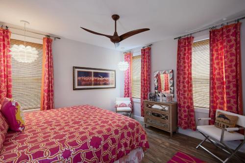a bedroom with a bed and a chair and windows at Gorgeous Villa in Coveted Butterknife Community in Sanibel