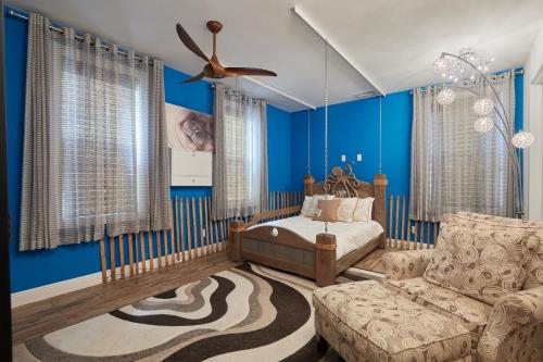 a bedroom with blue walls and a bed and a couch at Gorgeous Villa in Coveted Butterknife Community in Sanibel