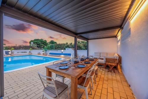 ein Esszimmer mit einem Tisch und einem Pool in der Unterkunft Casa Das Flores in Carvoeiro