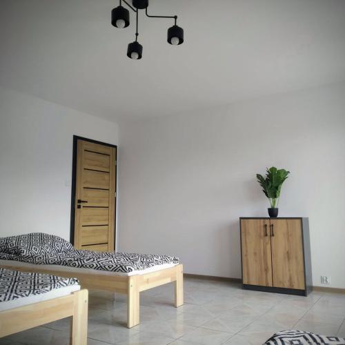 a room with a bed and a cabinet with a potted plant at Apartament blisko Parku i Granicy PL-DE in Łęknica