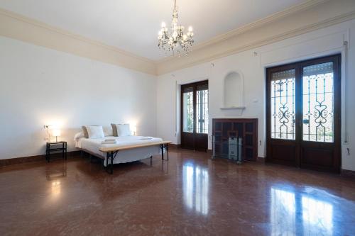 a large white room with a bed and a chandelier at Apartoyou - Finca Privada in El Puerto de Santa María