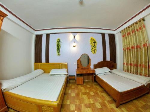 a bedroom with two beds and a mirror at Minh Hưng Hostel in Sa Pa
