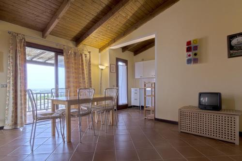 a dining room with a table and chairs and a television at bilocale ciclamino in Cuile Pazzoni