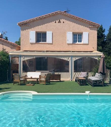 une maison avec une piscine devant une maison dans l'établissement La Bastide Neuve des Oliviers, à La Londe-les-Maures