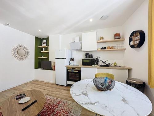 a living room with a table and a kitchen at Séjour en groupe Immeuble 10 pers, Aulnat in Aulnat
