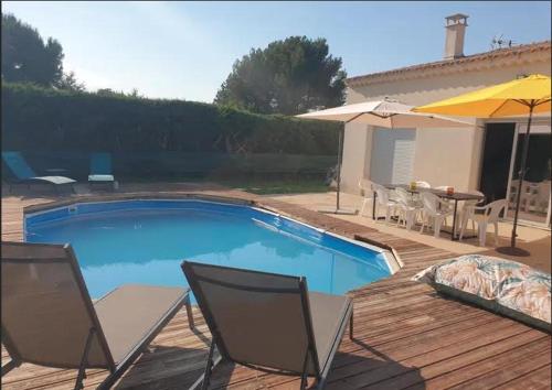 - une piscine avec des chaises, une table et un parasol dans l'établissement Belle maison region provence piscine climatisation cinq chambres dix personnes, à Mazan