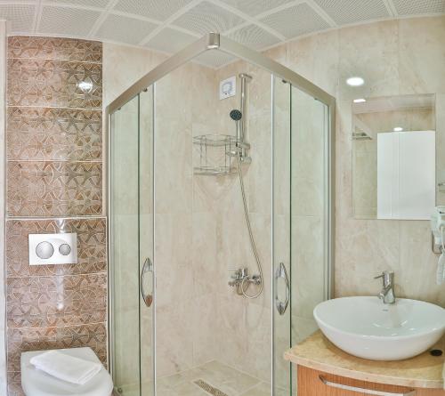 a bathroom with a shower and a sink at Hotel Kayahan in Kas
