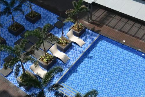 Una vista aérea de una piscina con palmeras. en 1 BR Executive Suite Gentry Manor by JMS, en Manila