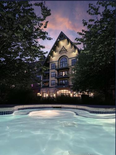a building with a large swimming pool in front of it at Cozy Mountain View Condo in Vernon Township