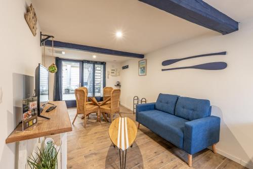Una sala de estar con un sofá azul y una mesa. en "Côte d'eau" Au cœur de la vieille ville - Appartements, en Boulogne-sur-Mer