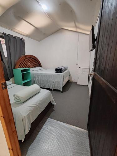 a small room with two beds and a tv at Casa Cálida Relajante y Céntrico con Estacionamiento in San Cristóbal de Las Casas