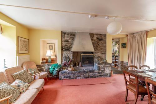 a living room with a fireplace and a stone wall at The Miller's House in Castle Douglas