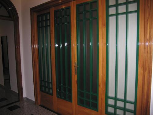 a pair of wooden doors with green glass at Business Apartments in Foggia
