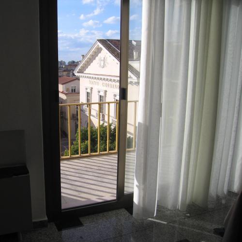 a door to a balcony with a view of a building at Business Apartments in Foggia