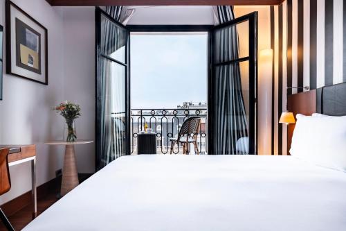 a bedroom with a large bed and a balcony at Grand Hôtel Champs-Elysées in Paris
