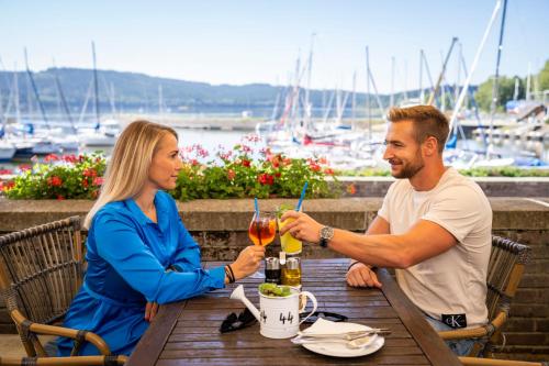 a man and a woman sitting at a table with drinks at Landal Marina Lipno in Lipno nad Vltavou