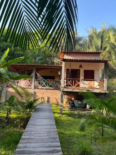 a house with a wooden walkway leading to it at Chalé Encantos do Una in Morros