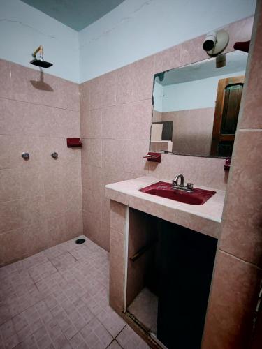 a bathroom with a red sink and a mirror at Casa Cálida Relajante y Céntrico con Estacionamiento in San Cristóbal de Las Casas
