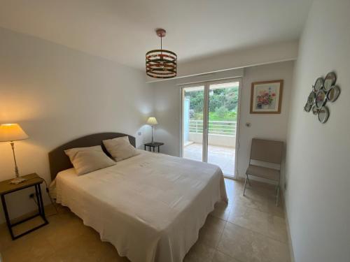 une chambre avec un grand lit blanc et une fenêtre dans l'établissement domaine de la baie, à Cavalaire-sur-Mer